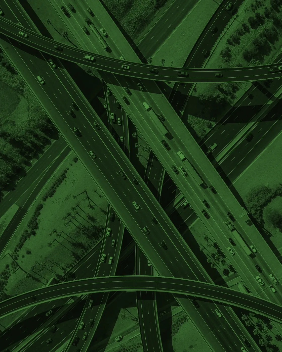 A green picture of an intersection with cars driving on it.