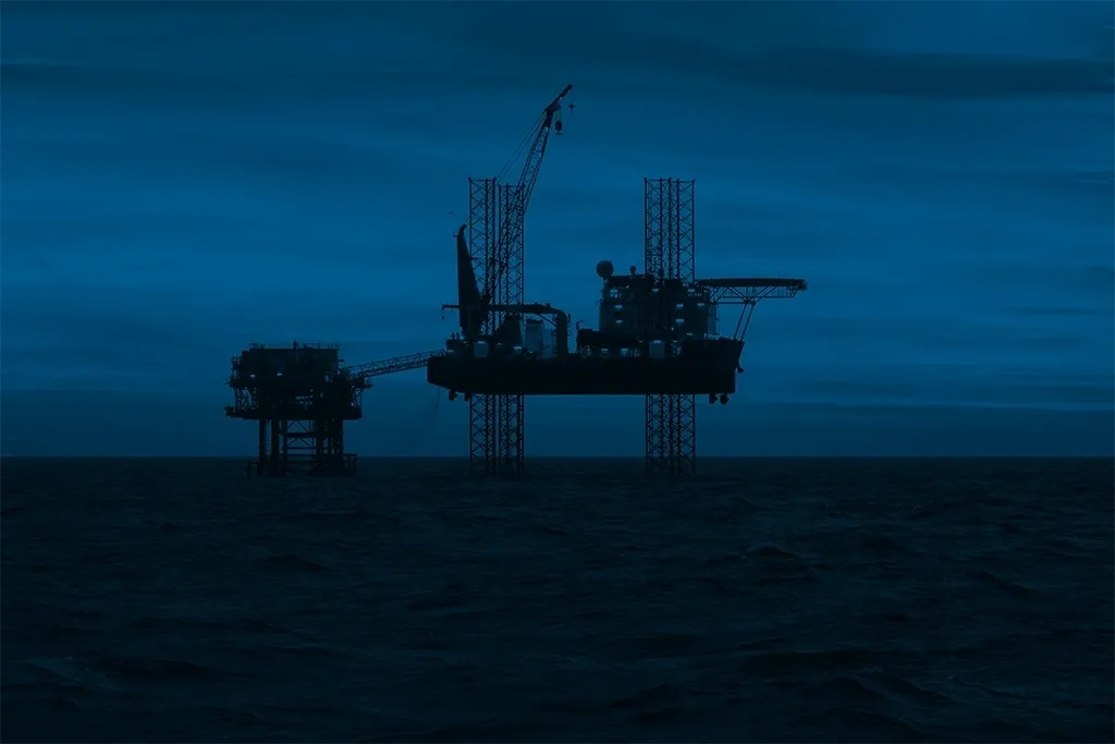 A large rig is in the middle of an ocean.